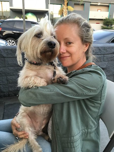 Michelle Hatch, founder of Pawtripper, smiling with her dog Eliza and celebrating their shared love of travel and dog-friendly adventures.