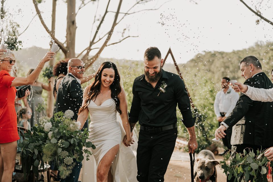 Newlyweds-Mandy-and-Alex-walking-down-the-aisle-with-their-pet-dog